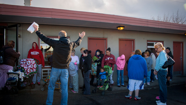 man praying over shelter dinner