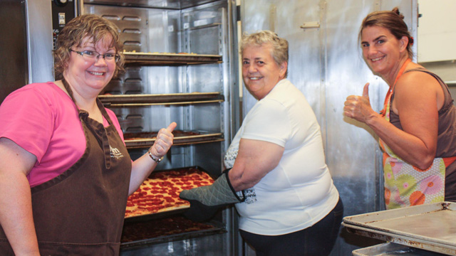 Camp kitchen workers making pizza