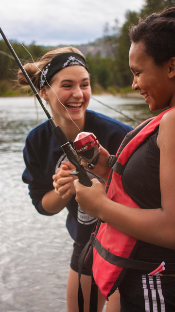 counselor laughing and fishing with young girl