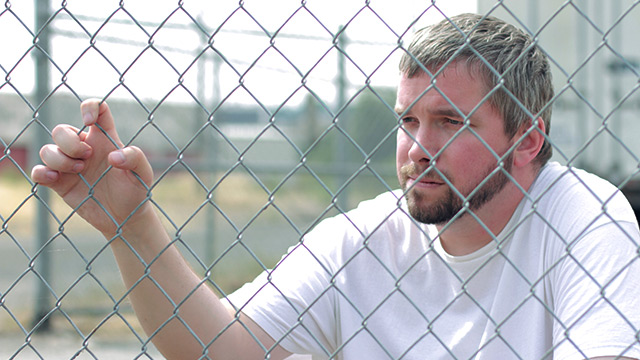 Eric standing by fence