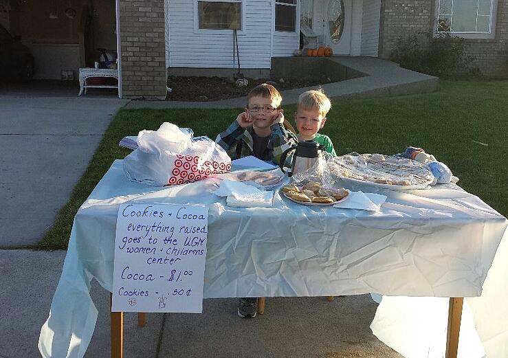 child sells cocoa and cookies for poor