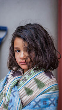 Little girl wrapped in blanket at shelter