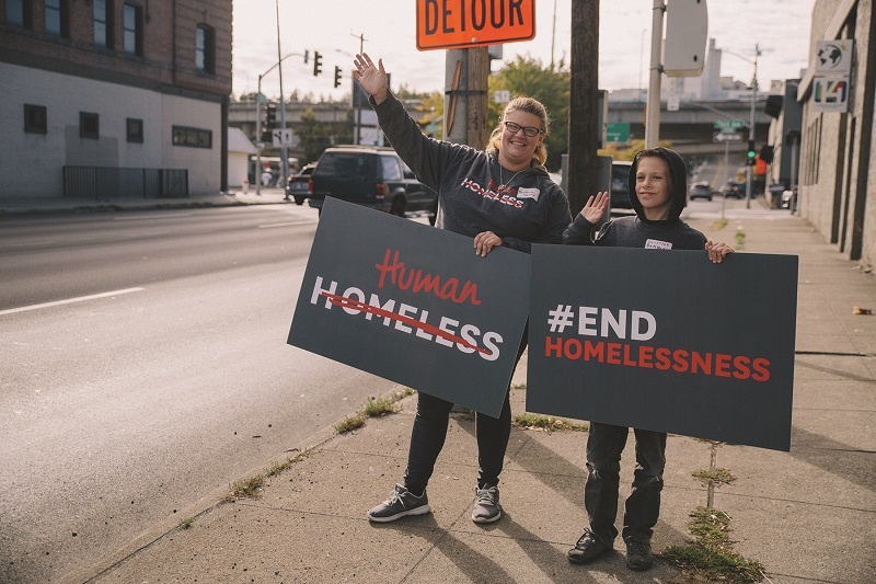 Barbara and Damyen waved signs as part of World Homeless Day 2018.