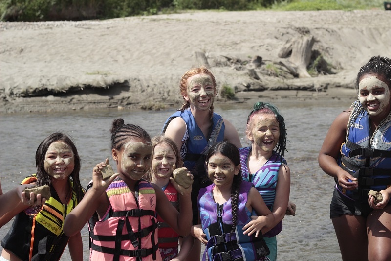 Girls enjoy a nice "spa mask" with the Spokane River clay at UGM Camp.