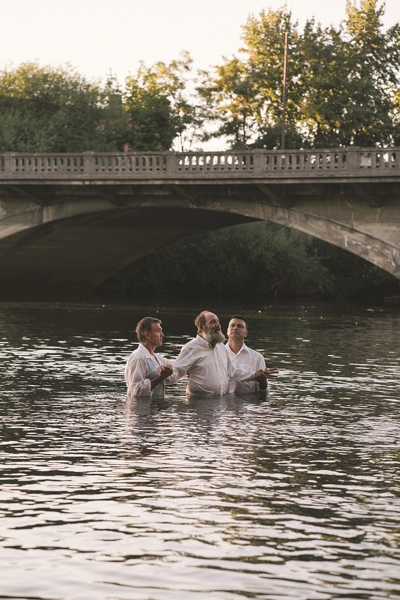 Jody is baptized by Randy Altmeyer and Ron Molina in the Spokane River outside the Union Gospel Mission.