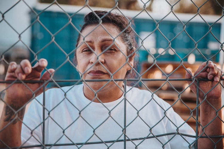 Kathy behind chainlink fence