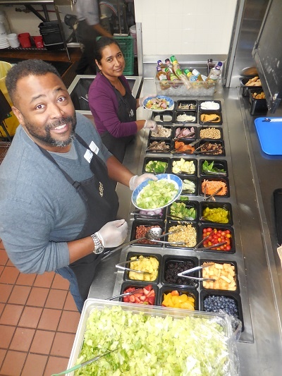 Volunteers help feed the hungry at the salad bar.