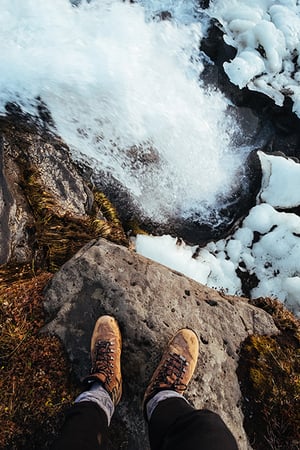 feet on rock by water